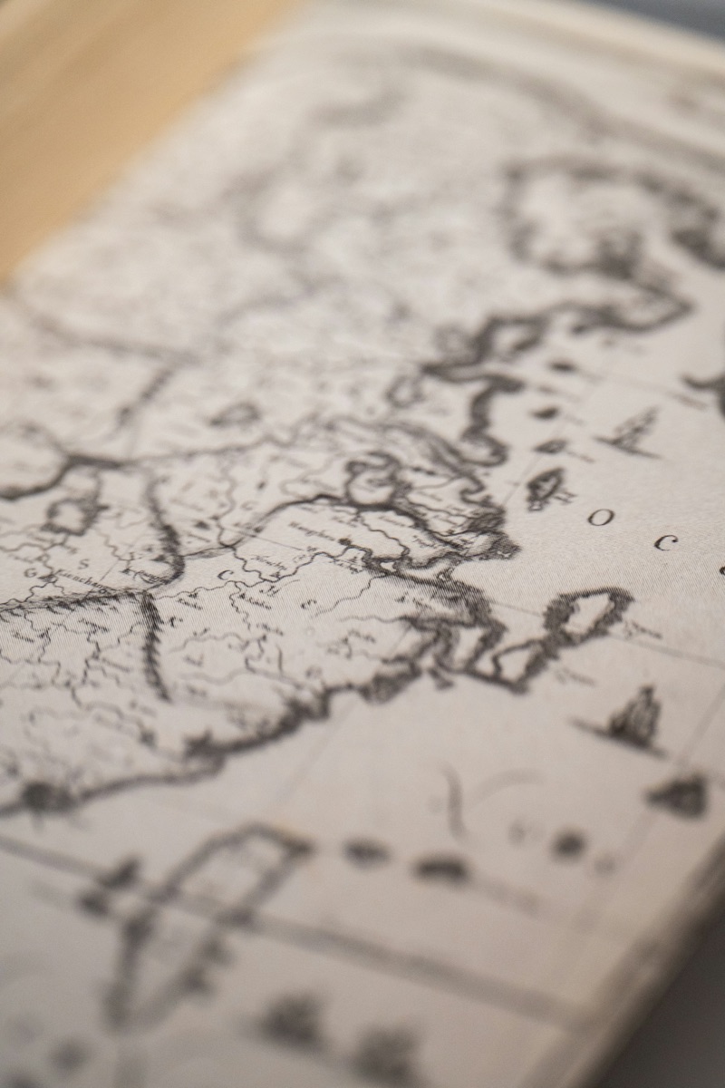 A close-up of an old engraved map, its coastlines and place names hand-lettered
